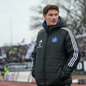 Merlin Polzin guckt grimmig an der Seitenlinie mit Händen in der Jackentasche