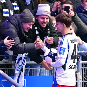 Otto Stange erfüllt an der Tribüne Autogrammwünsche der HSV-Fans
