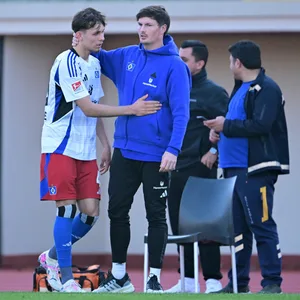 Merlin Polzin klatscht am Seitenrand mit Otto Stange ab