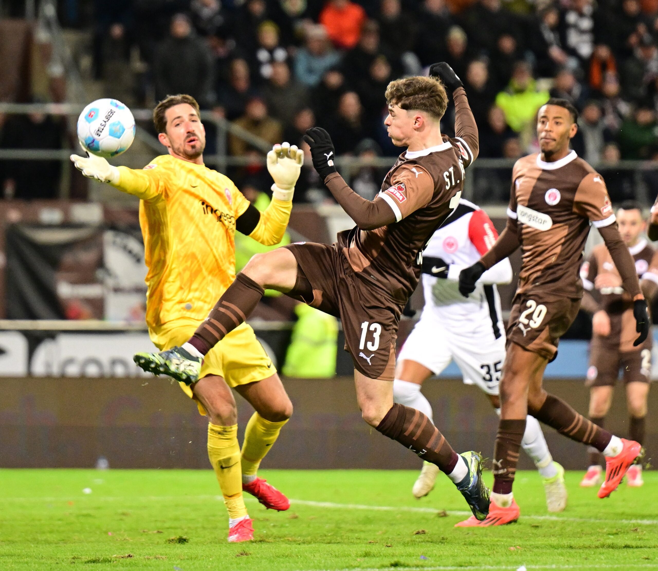 Noah Weißhaupt versucht, den Ball an Frankfurts Torwart Kevin Trapp vorbeizuspitzeln.