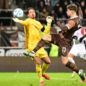 Noah Weißhaupt versucht, den Ball an Frankfurts Torwart Kevin Trapp vorbeizuspitzeln.