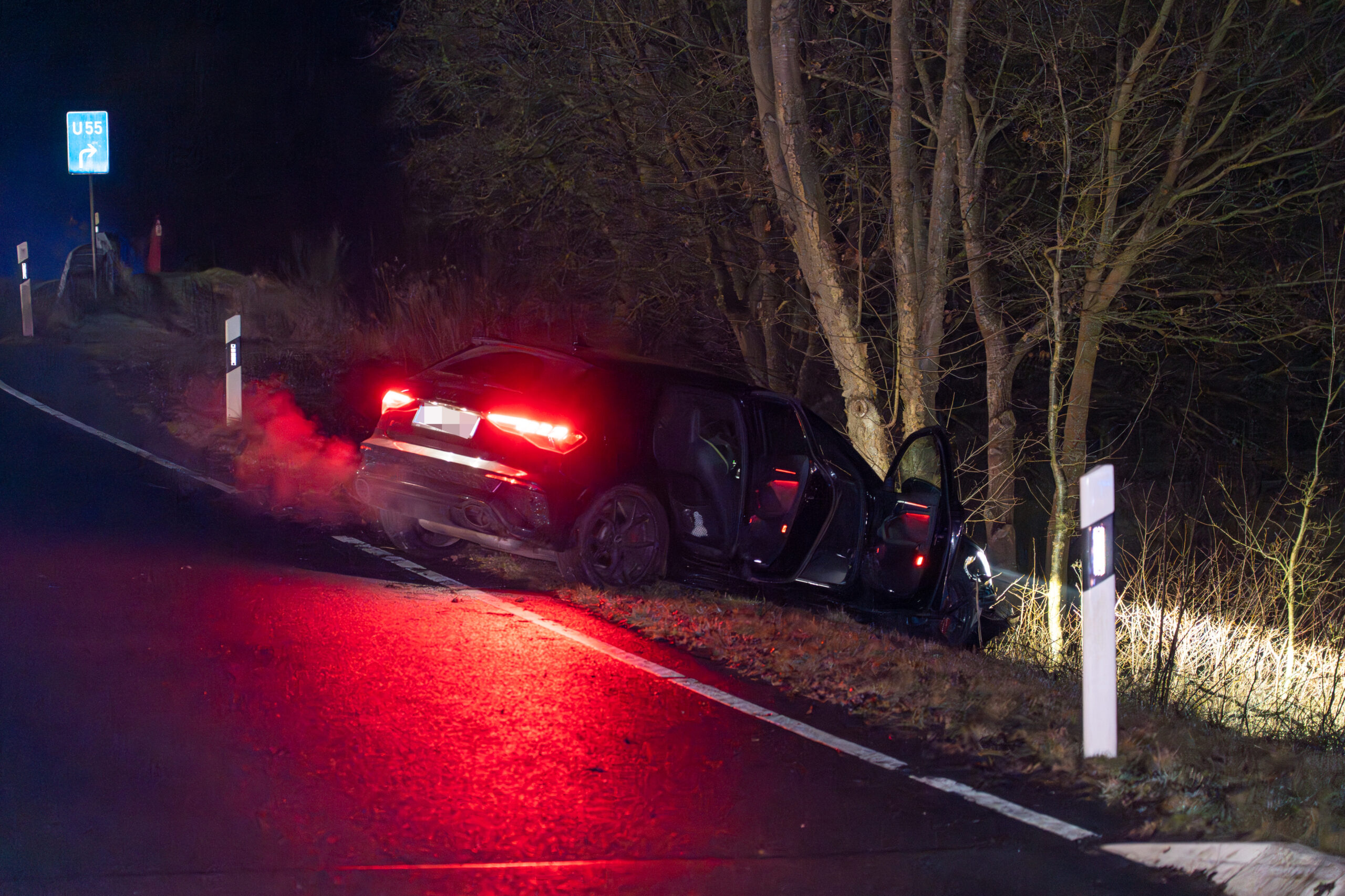 Das Fluchtfahrzeug steht nach dem Zugriff der Polizei mit geöffneten Türen am Rand der Böschung an der B440.