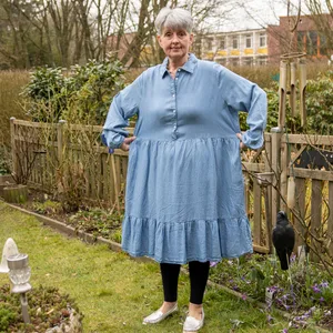 Frau mit zu großem Kleid in Garten