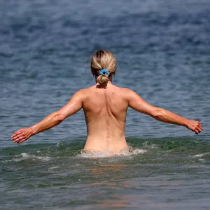 Diese Frau hält sich an das Gebot, ohne Kleidung am FKK-Strand zu baden.