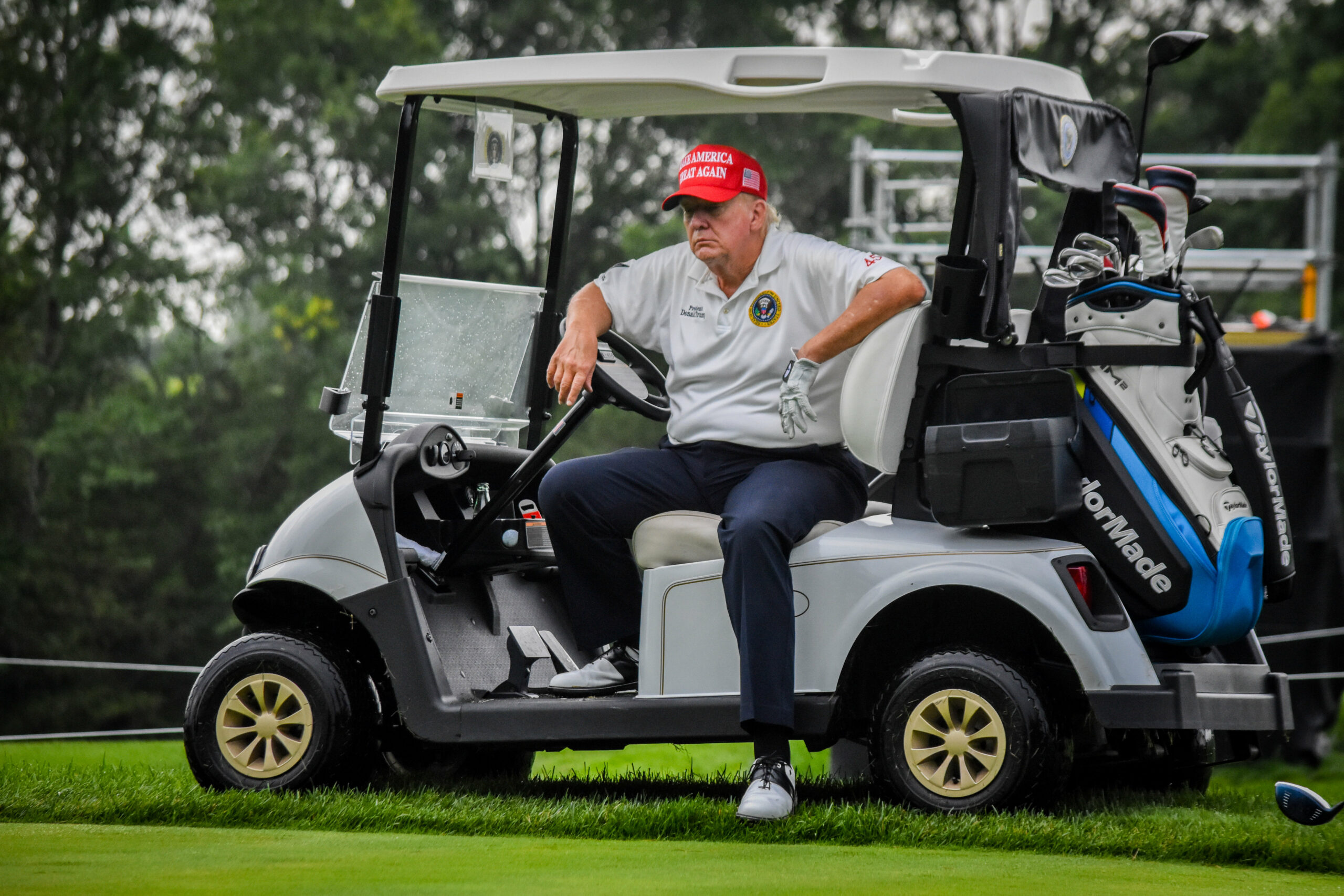 Donald Trump sitzt im Golf-Caddy