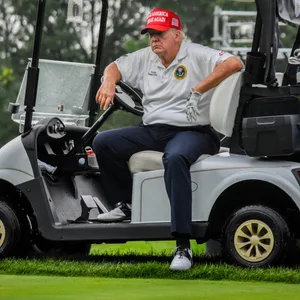 Donald Trump sitzt im Golf-Caddy