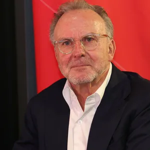 Karl-Heinz Rummenigge trägt einen Anzug und eine Brille