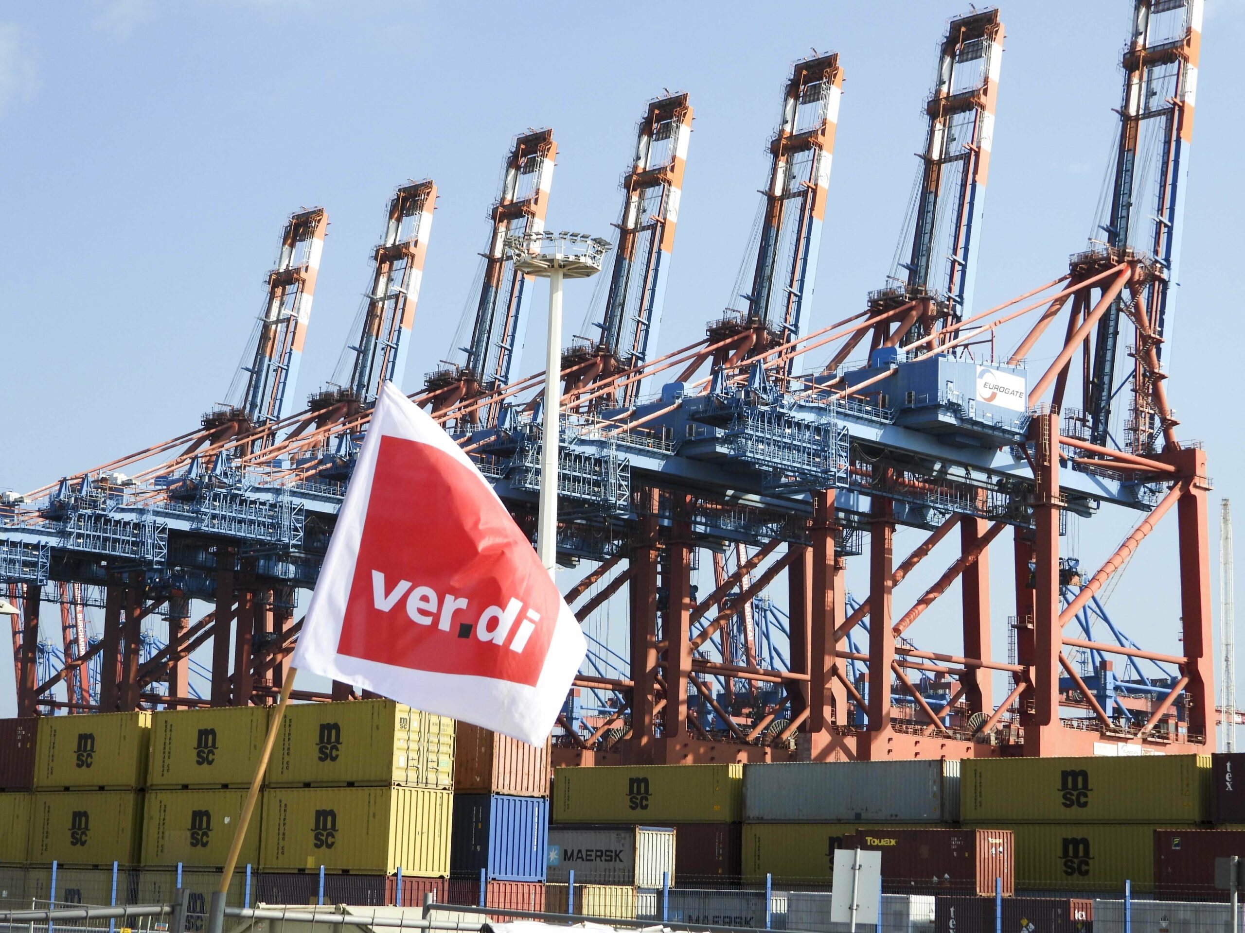 Eine Verdi-Flagge vor der Hafenkulisse.