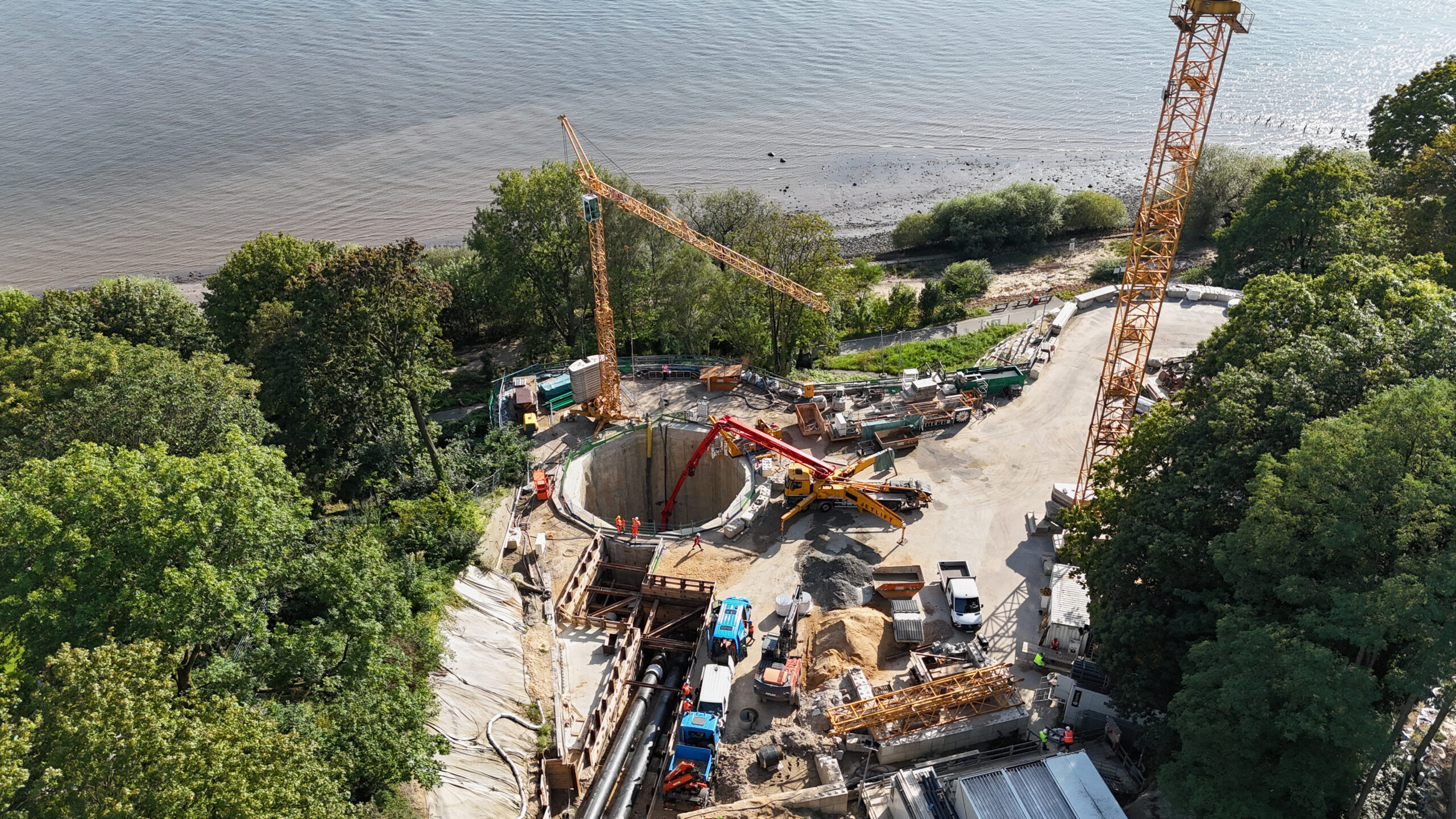 Drohnenfoto einer Tunnelbaustelle, im Hintergrund die Elbe