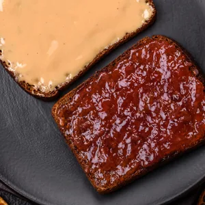 Sandwiches mit Toastbrot, Erdnussbutter und Himbeer- oder Erdbeermarmelade