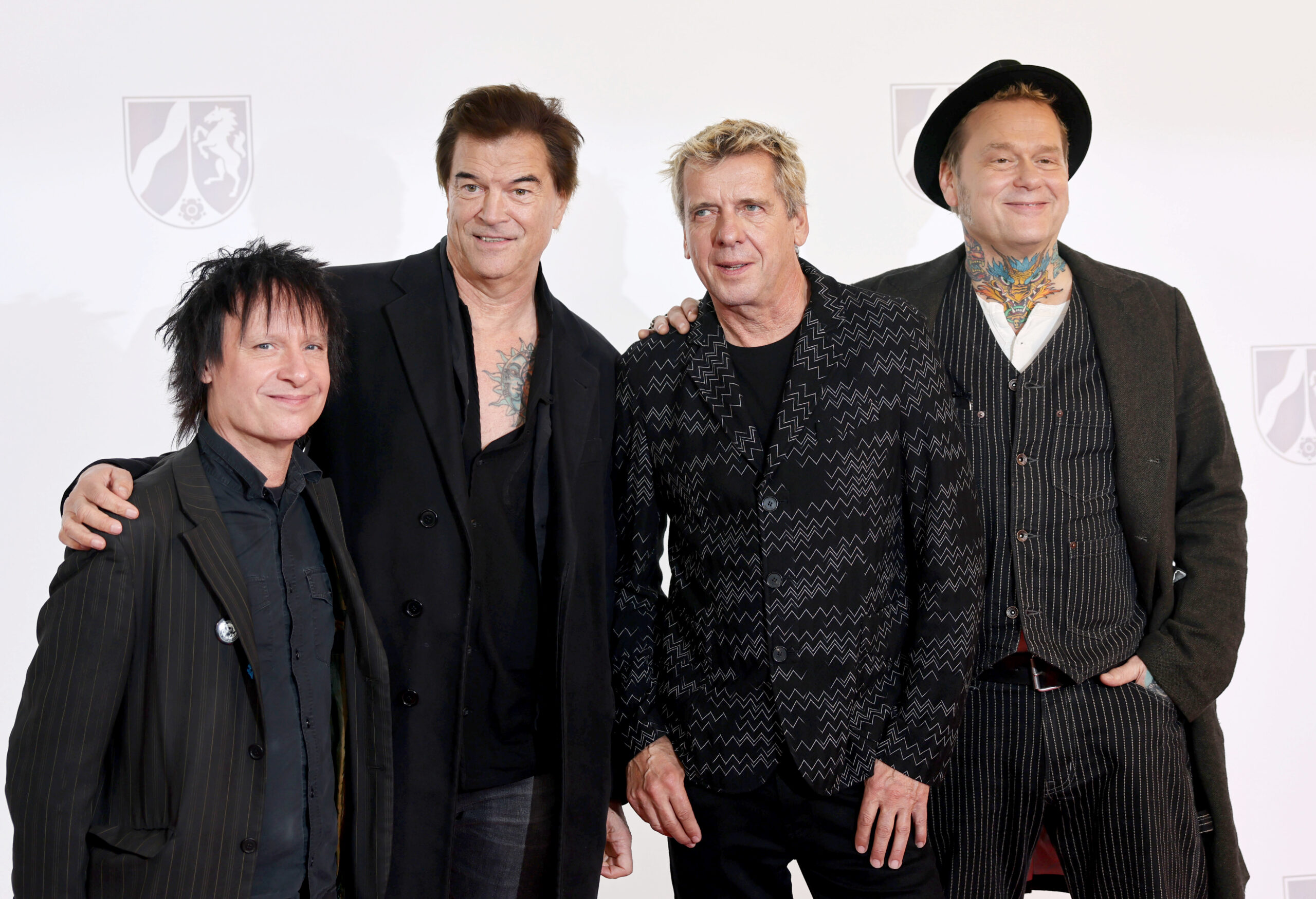 Die Band „Die Toten Hosen“ mit Stephen George Ritchie (v.l.), Andreas Frege alias Campino, Andreas Meurer und Andreas von Holst stehen auf einem roten Teppich.