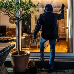 Ein Einbrecher steigt über die Terrasse ein. (Symbolbild)