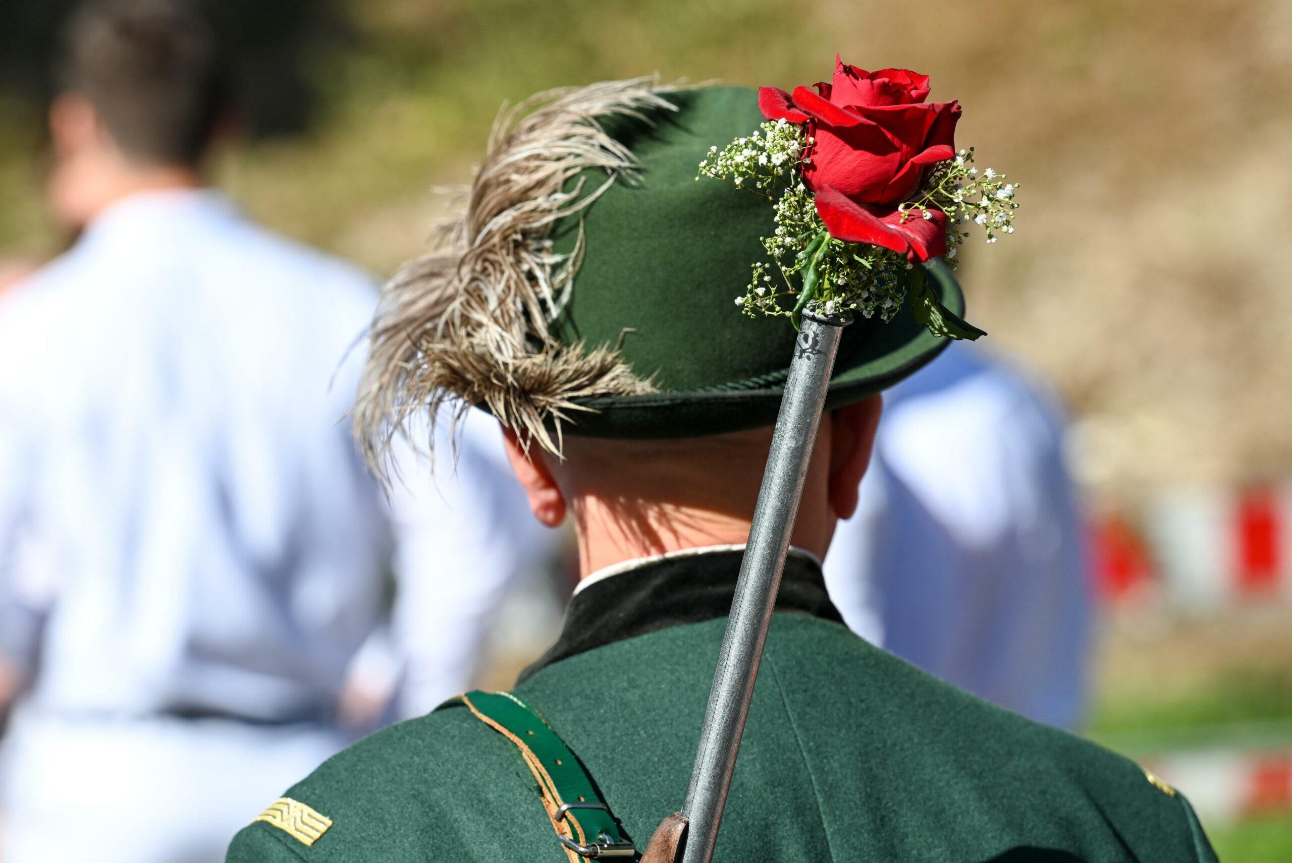 Ein Bürgerschütze hat sein geschmücktes Gewehr geschultert beim Schützenfest.