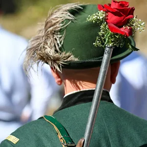 Ein Bürgerschütze hat sein geschmücktes Gewehr geschultert beim Schützenfest.