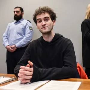 Der Angeklagte Loic Schneider (M) sitzt im Gerichtssaal zwischen seiner Anwältin Carolin Kaufmann (r) und einem Justizbeamten