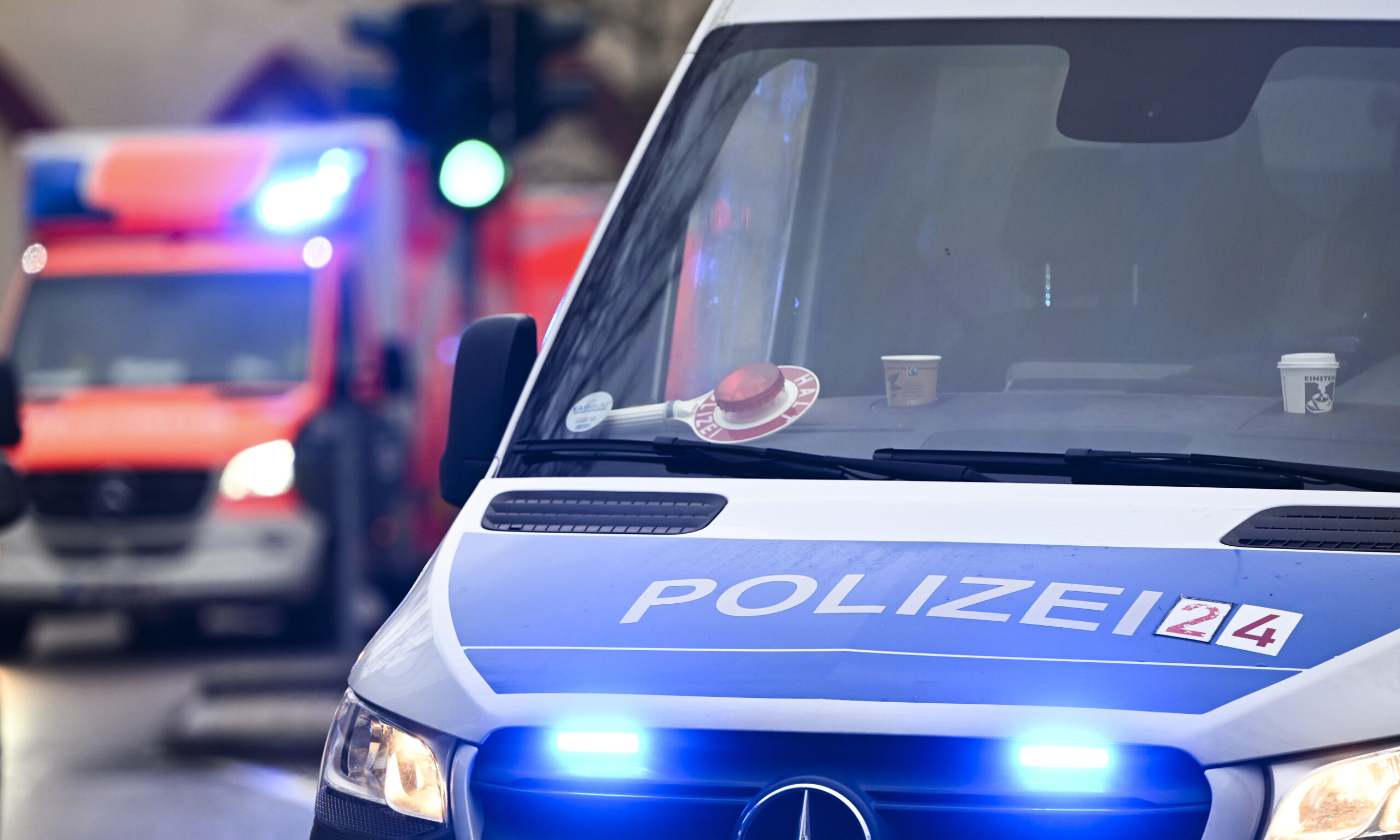 Ein Polizeiauto und ein Rettungswagen mit Blaulicht.