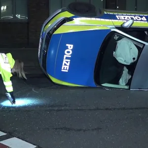 Unfall auf Einsatzfahrt – Polizeiauto landet auf Dach