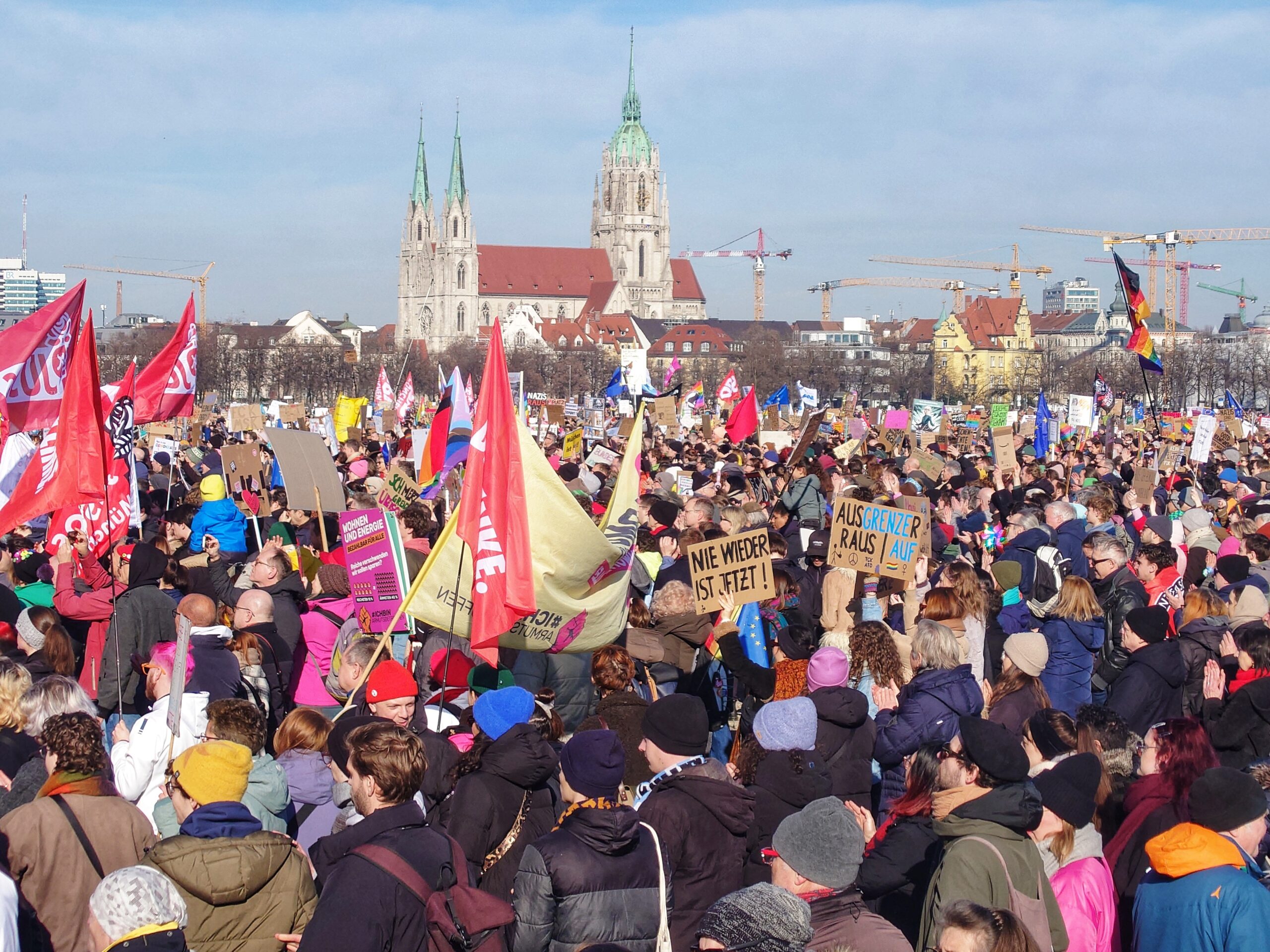 Demonstranten halten Fahnen und Plakate in die Höhe.