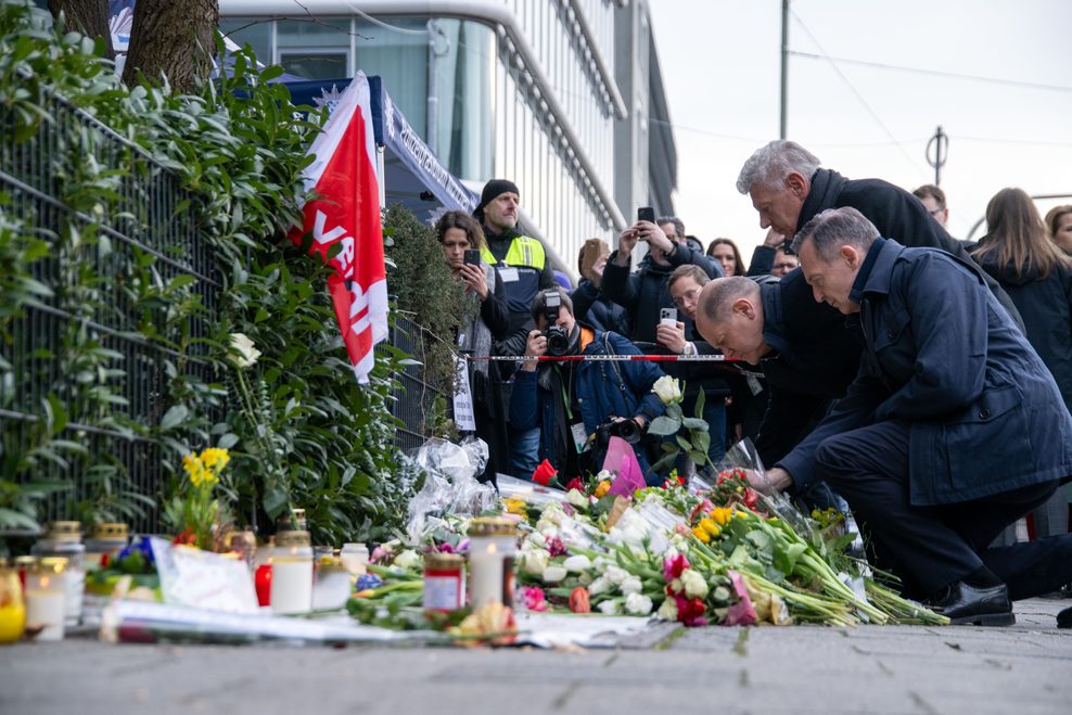 Bundeskanzler Olaf Scholz (SPD, v.l.), Münchens Oberbürgermeister Dieter Reiter (SPD) und Bundesverkehrsminister Volker Wissing (parteilos) legen weiße Rosen an der Stelle nieder, wo am 13. Februar ein Auto in eine Verdi Demonstration gerast war.