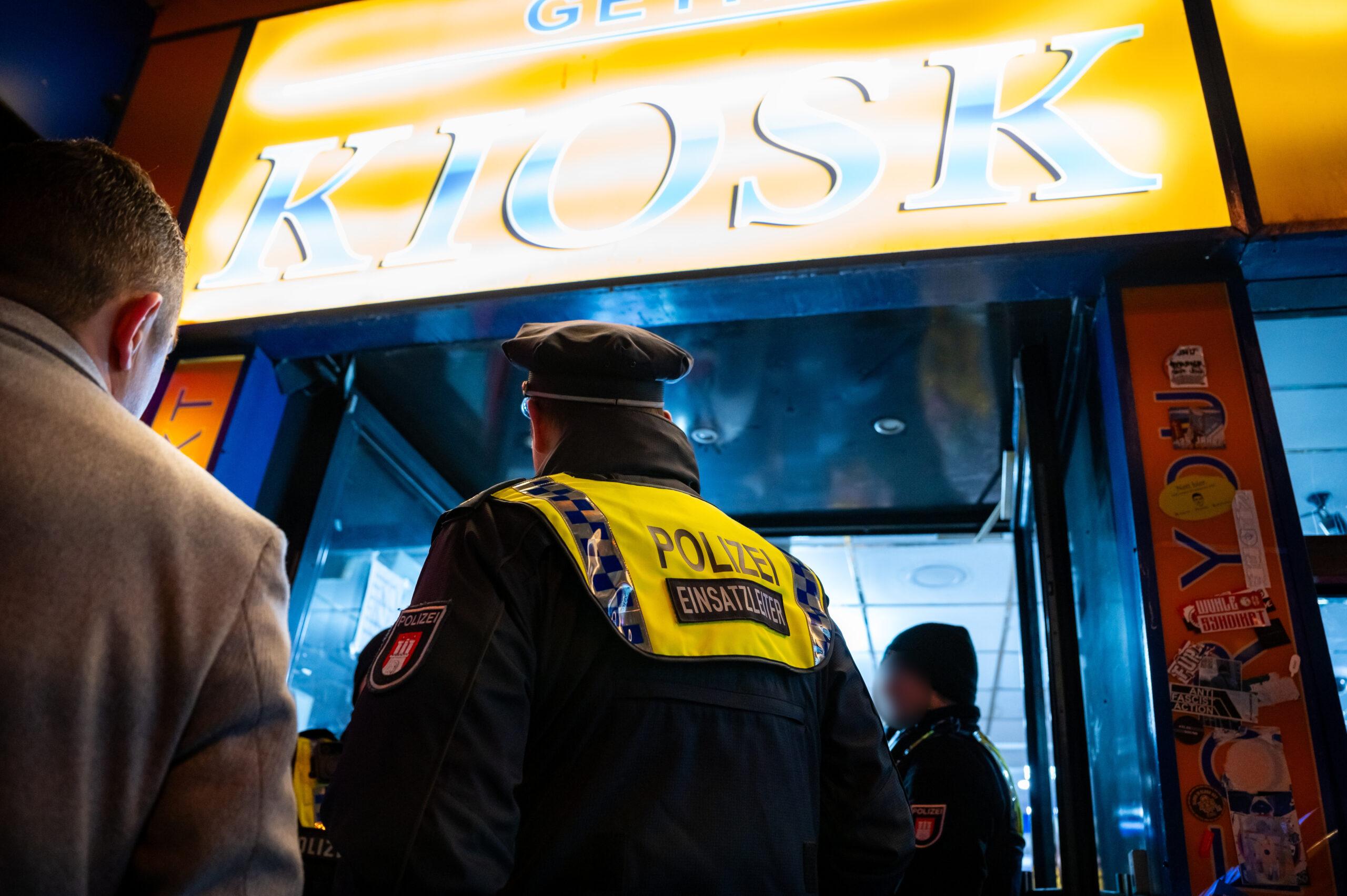 Polizisten stehen vor einem kontrollierten Kiosk.