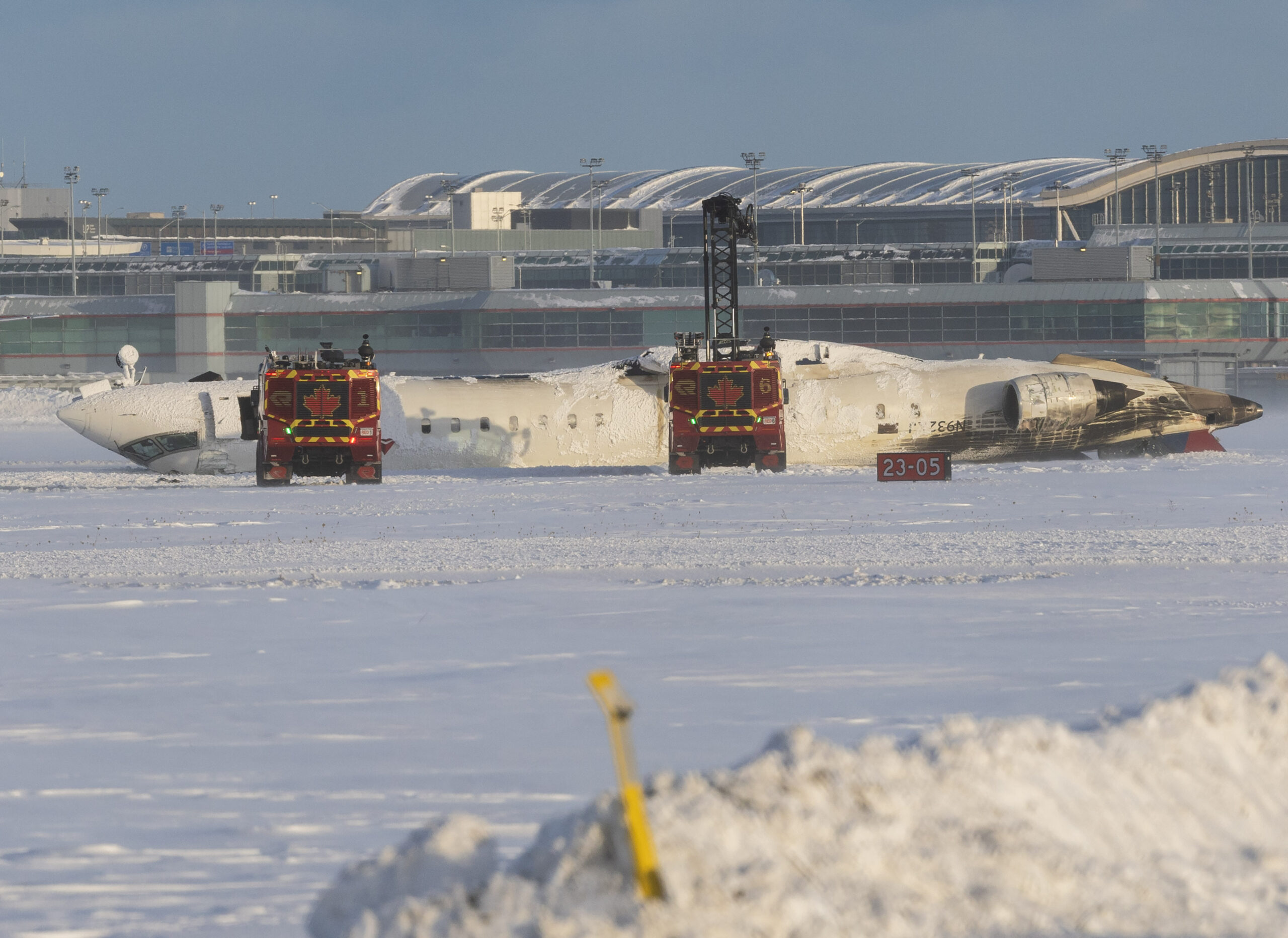 Ein Flugzeug lieg auf der verschneiten Landebahn auf dem Rücken.