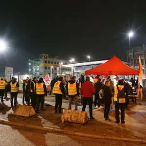 Streikende halten sich vor dem Paketzentrum der Post im Hamburger Stadtteil Allermöhe auf.