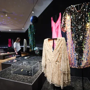 Glitzernde Kostüme stehen im Museum für Kunstgewerbe.