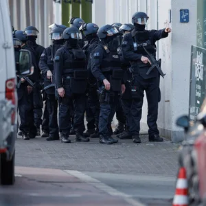 Schwerbewaffnete Einsatzkräfte der Polizei sichern eine Straße vor dem Landgericht in der Innenstadt.