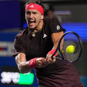 Alexander Zverev streckt seine Zunge raus und trifft den Ball mit seinem Schläger