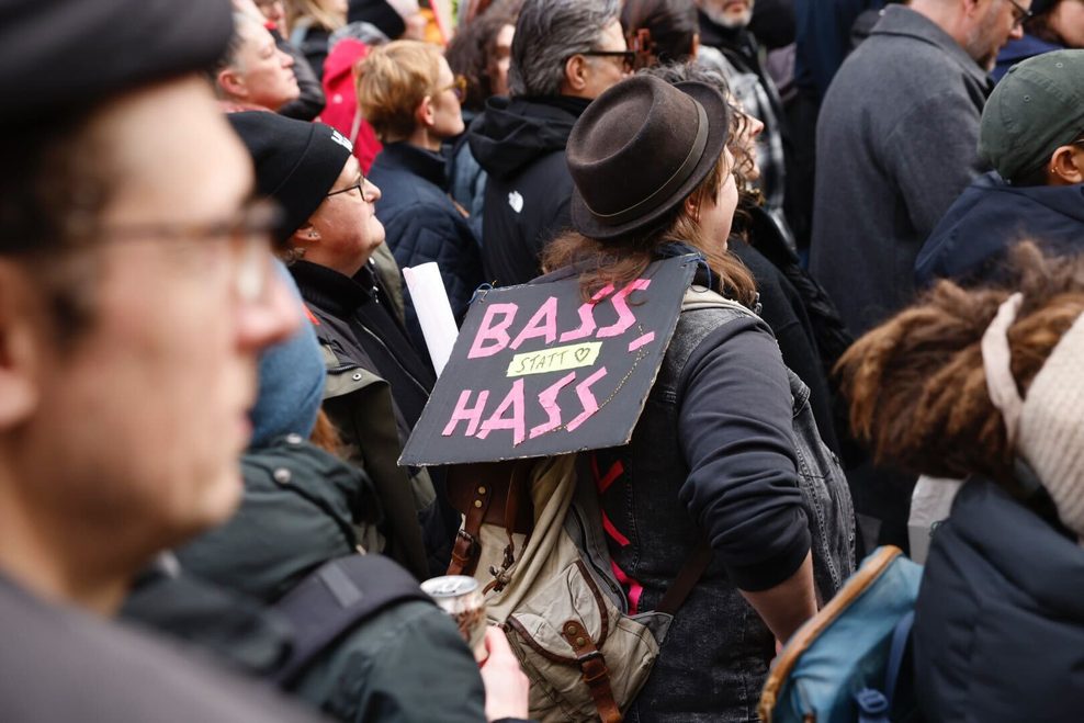 „Bass statt Hass“ steht auf dem Plakat einer Demonstrantin.