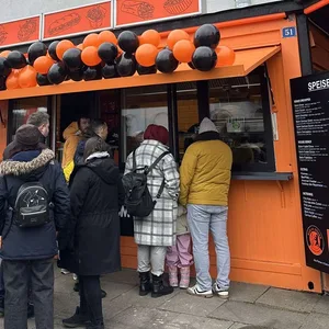 Gäste warten vor dem Imbiss auf ihren Döner.