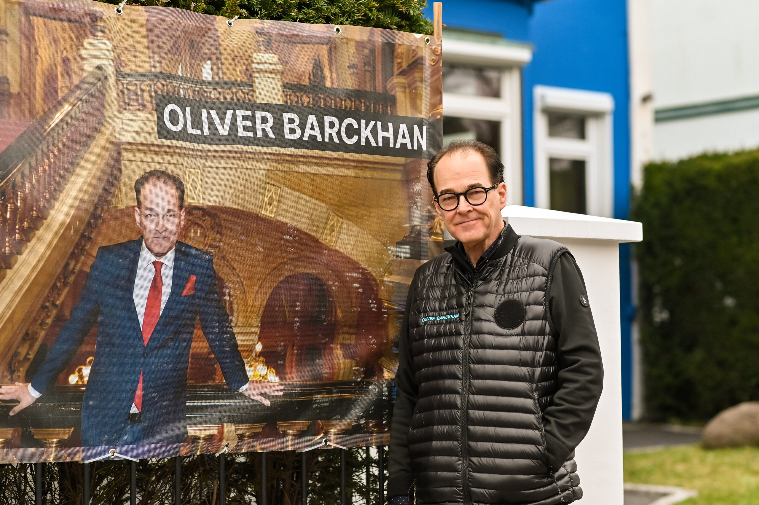 Mann vor Plakat mit der Aufschrift Oliver Brackhan