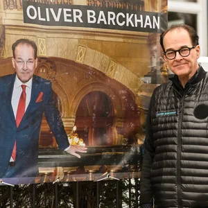 Mann vor Plakat mit der Aufschrift Oliver Brackhan