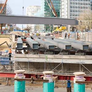 Ein Kran hebt einen Stahlträger für die Berlinertordammbrücke in Hamburg ein.