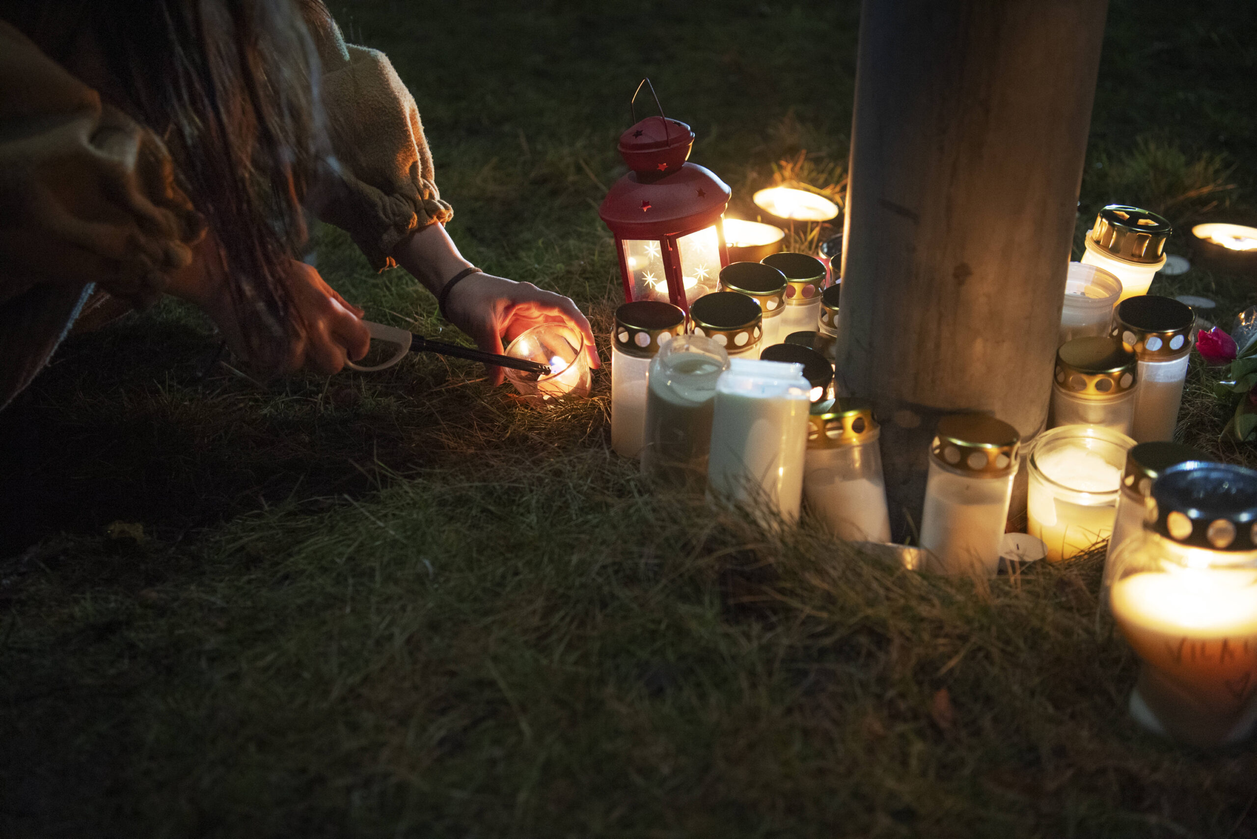 Eine Person zündet Kerzen am Ort des Attentats an.