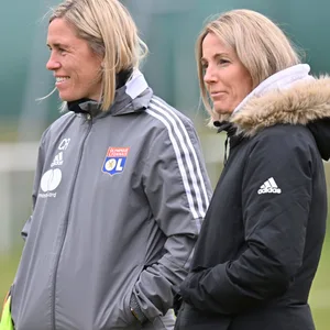 Camille Abily und Sonia Bompastor lächeln auf dem Trainingsplatz.