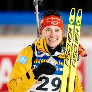 Biathletin Janina Hettich-Walz hält ihre Silbermedaille in die Kamera