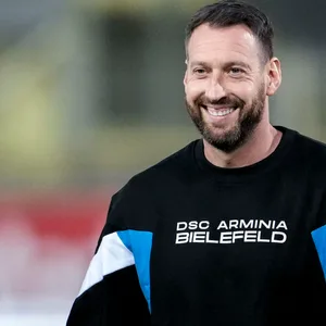 Mitch Kniat im Bielefeld-Pullover lächelt.