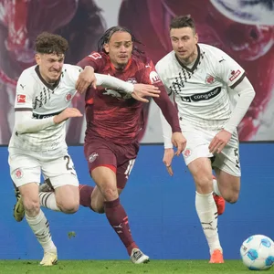 Philipp Treu und Hauke Wahl versuchen Xavi Simons zu stoppen.