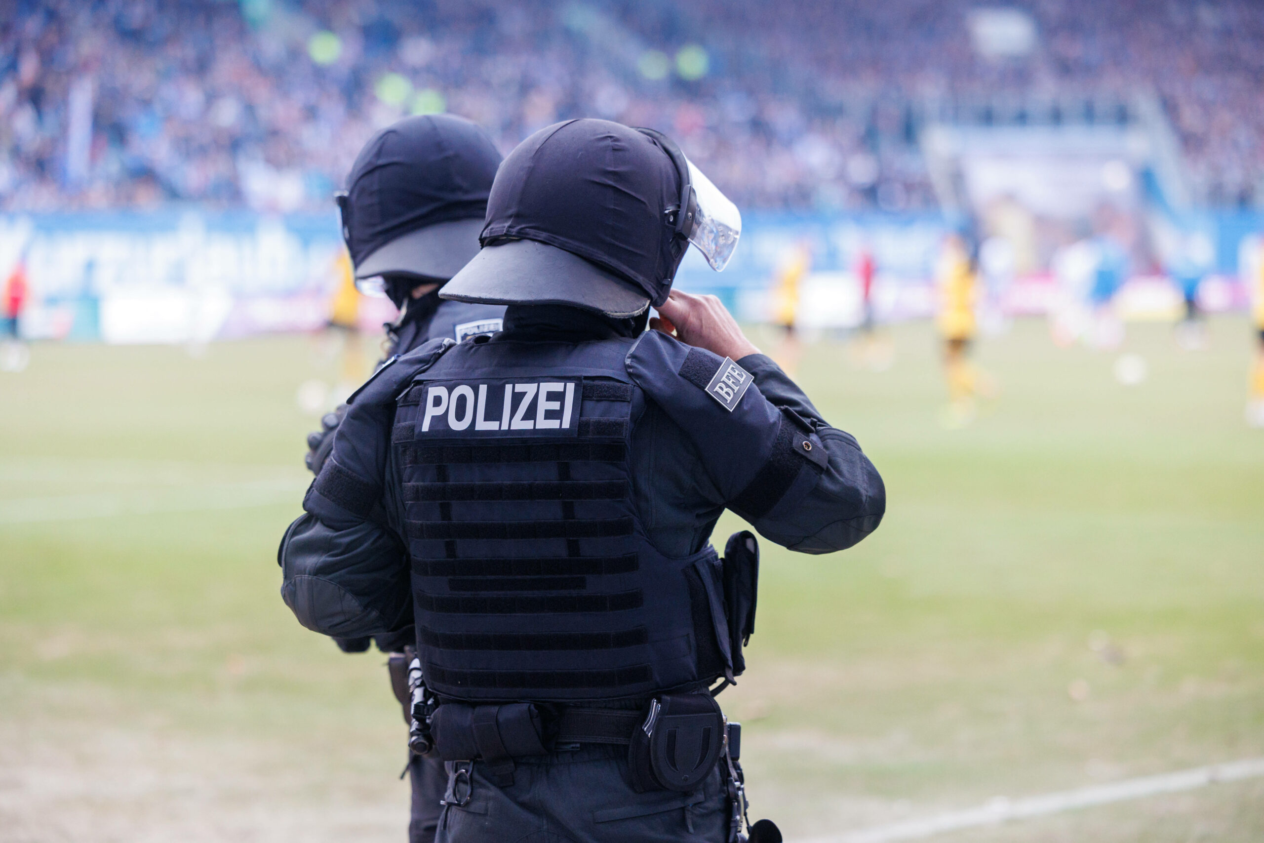 Zwei Polizisten beobachtet ein Fußballspiel in Rostock