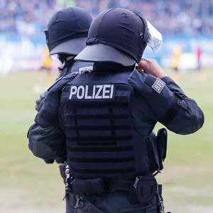 Zwei Polizisten beobachtet ein Fußballspiel in Rostock