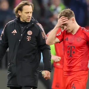 Joshua Kimmich fasst sich an die Stirn, neben ihm stehen zwei Ärzte