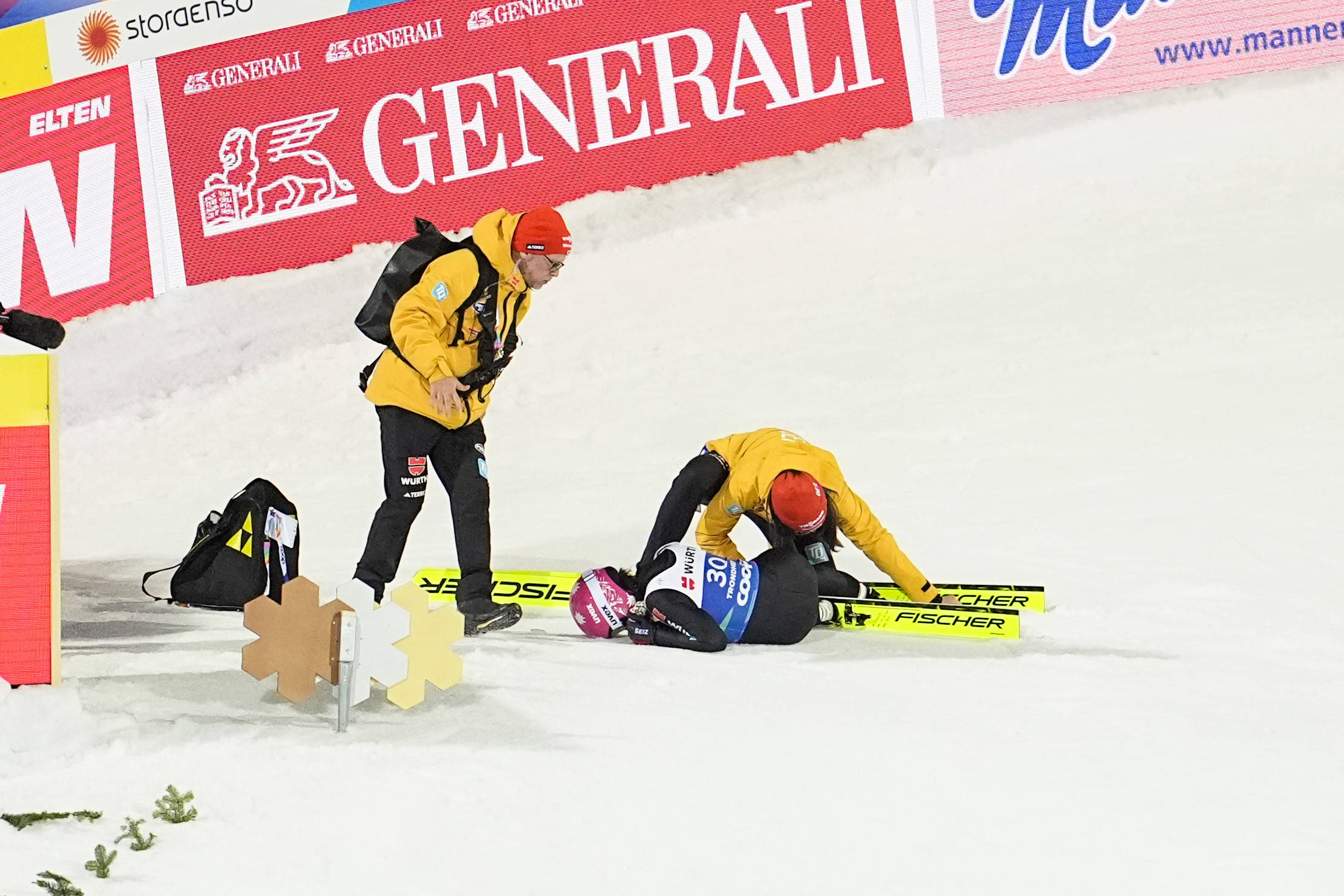 Luisa Görlich liegt nach einem Sturz am Boden. Betreuer helfen ihr aus den Skiern zu kommen.