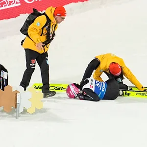 Luisa Görlich liegt nach einem Sturz am Boden. Betreuer helfen ihr aus den Skiern zu kommen.