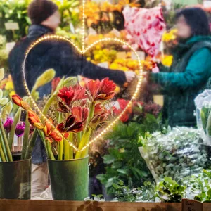 Zahlreiche Menschen kaufen am Valentinstag in einem Blumenladen ein. (Symbolbild)