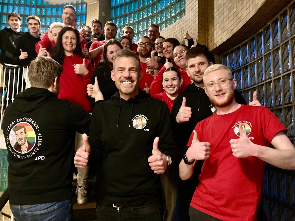 Weiße Zähne und rote und schwarze Shirts: Falko Droßmann (M.) und sein Wahlkampfteam.