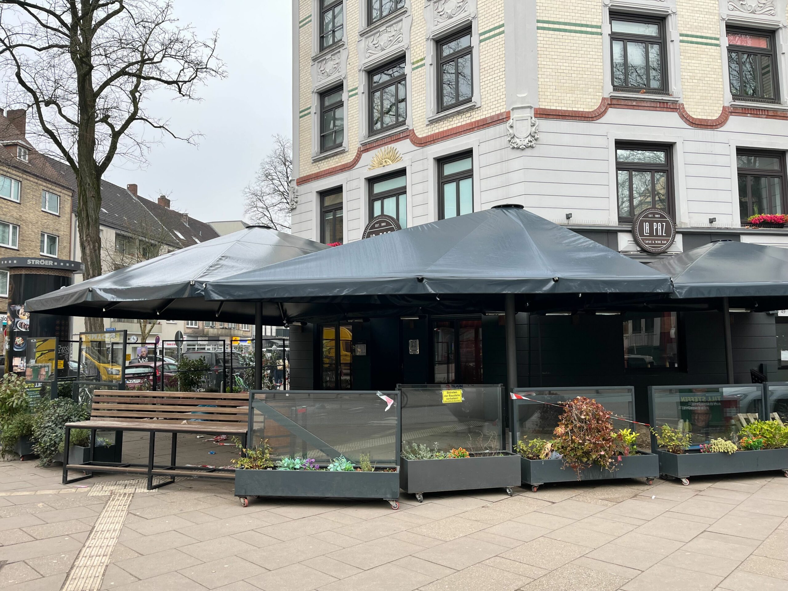 Große schwarze Schirme über Restaurantterrasse