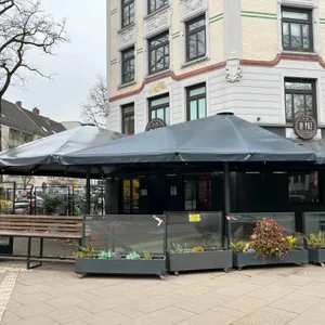Große schwarze Schirme über Restaurantterrasse