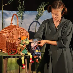 Eine Puppenspielerin mit den Figuren eines Froschs und eines Maulfwurfs.