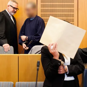 Die angeklagten Eltern sprechen vor Prozessbeginn in Mainz mit ihren Anwälten. (Archivbild)